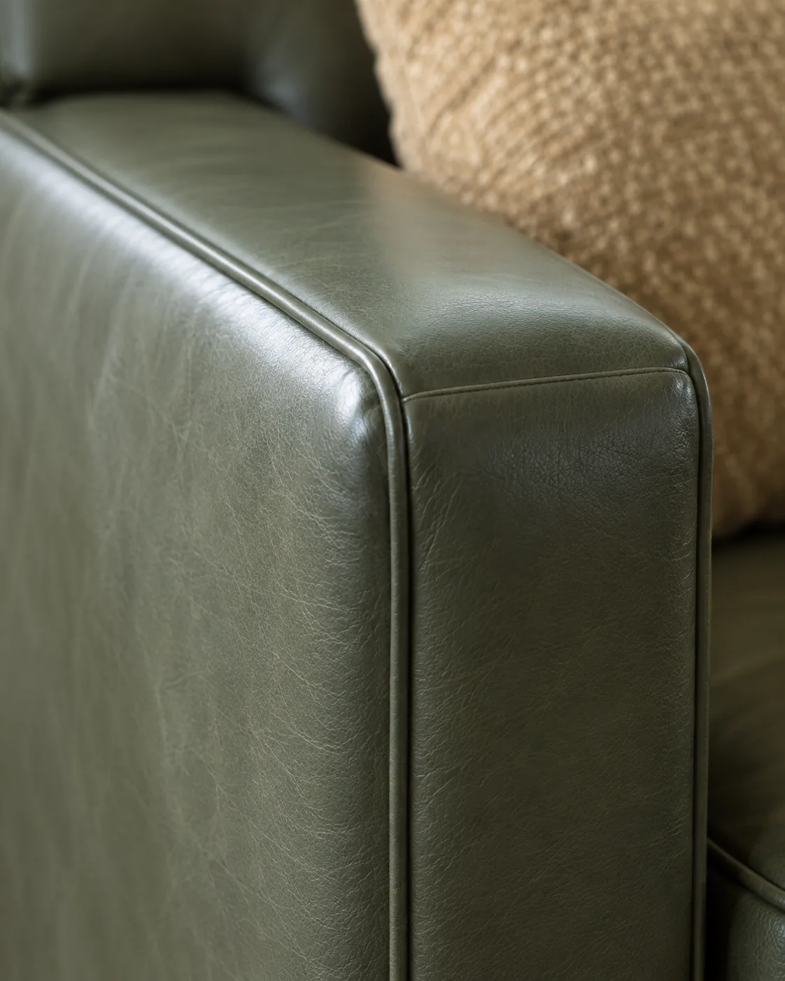 A squared-off green leather track arm
