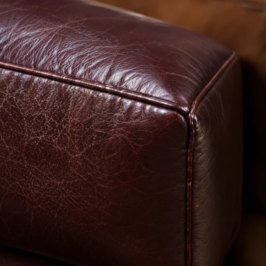Corner of a burgundy leather sofa with a tight, low-sheen grain