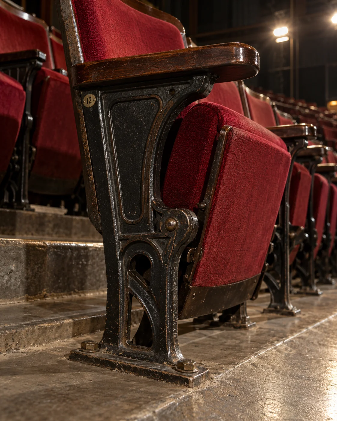 The cast iron standard and gravity hinge of an auditorium seat