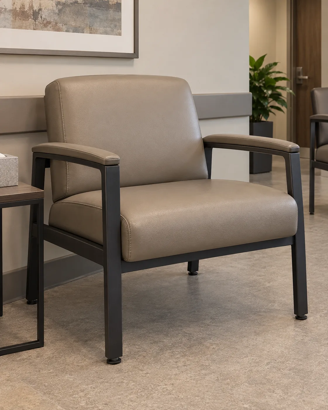 A wide bariatric waiting room chair in taupe vinyl