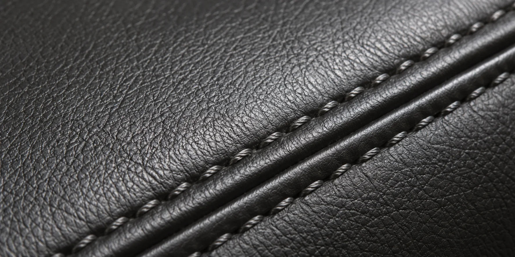 Close view of twin stitching along a black leather seam