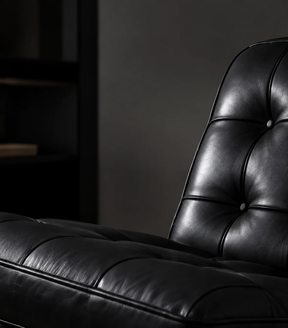 Black tufted leather sofa with low back
