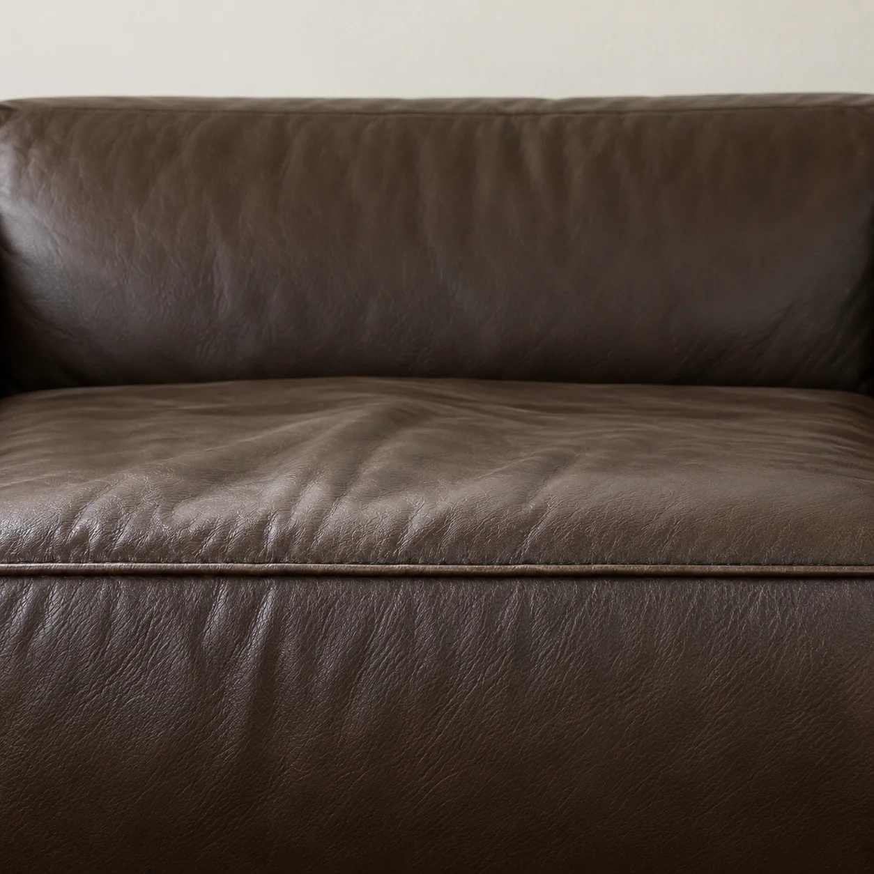 Creased brown leather seat cushion losing its support