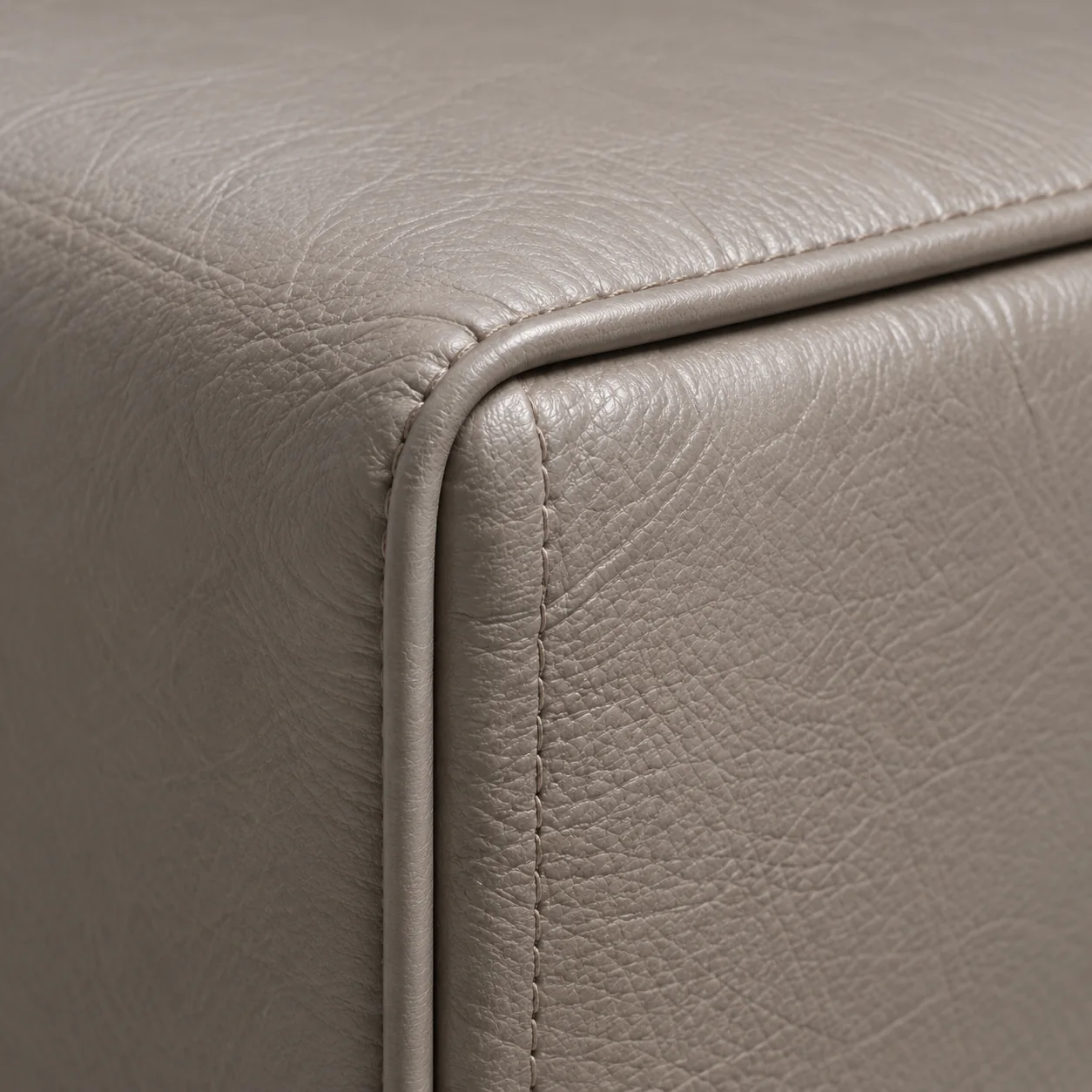 Corner of a taupe leather panel with piping on two edges