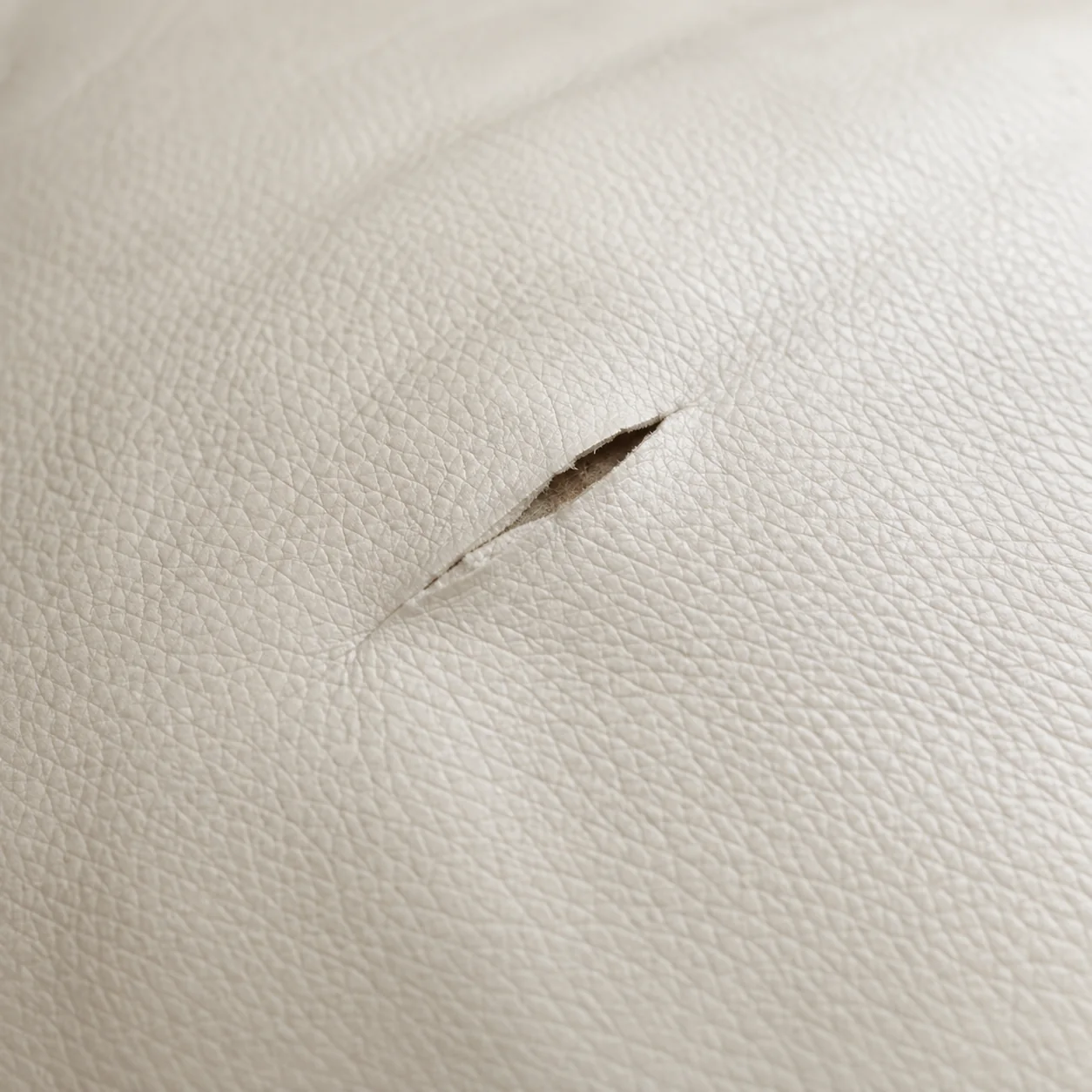Small tear in a pale leather panel