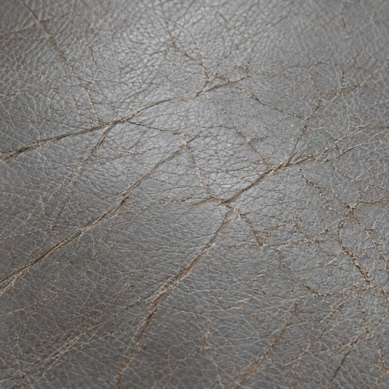 Crazed surface wear across a grey leather panel