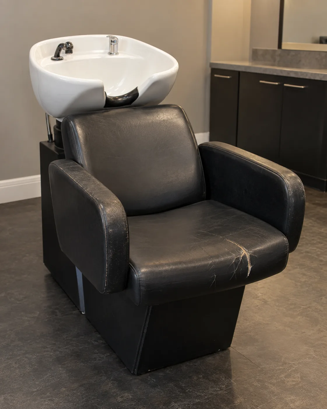 A shampoo chair with a split black seat