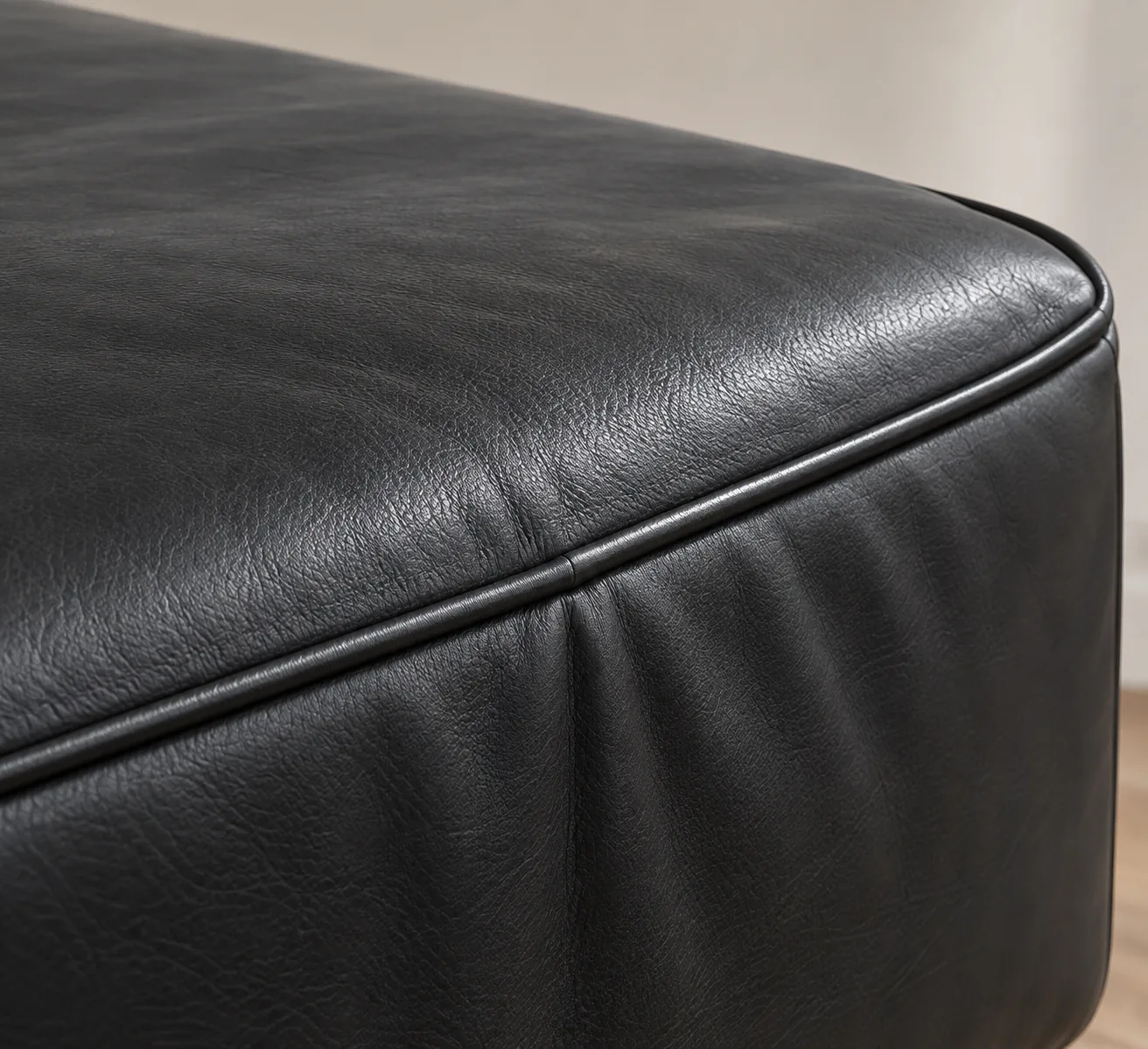 Black leather bench corner with the cover loose and rippling above the frame