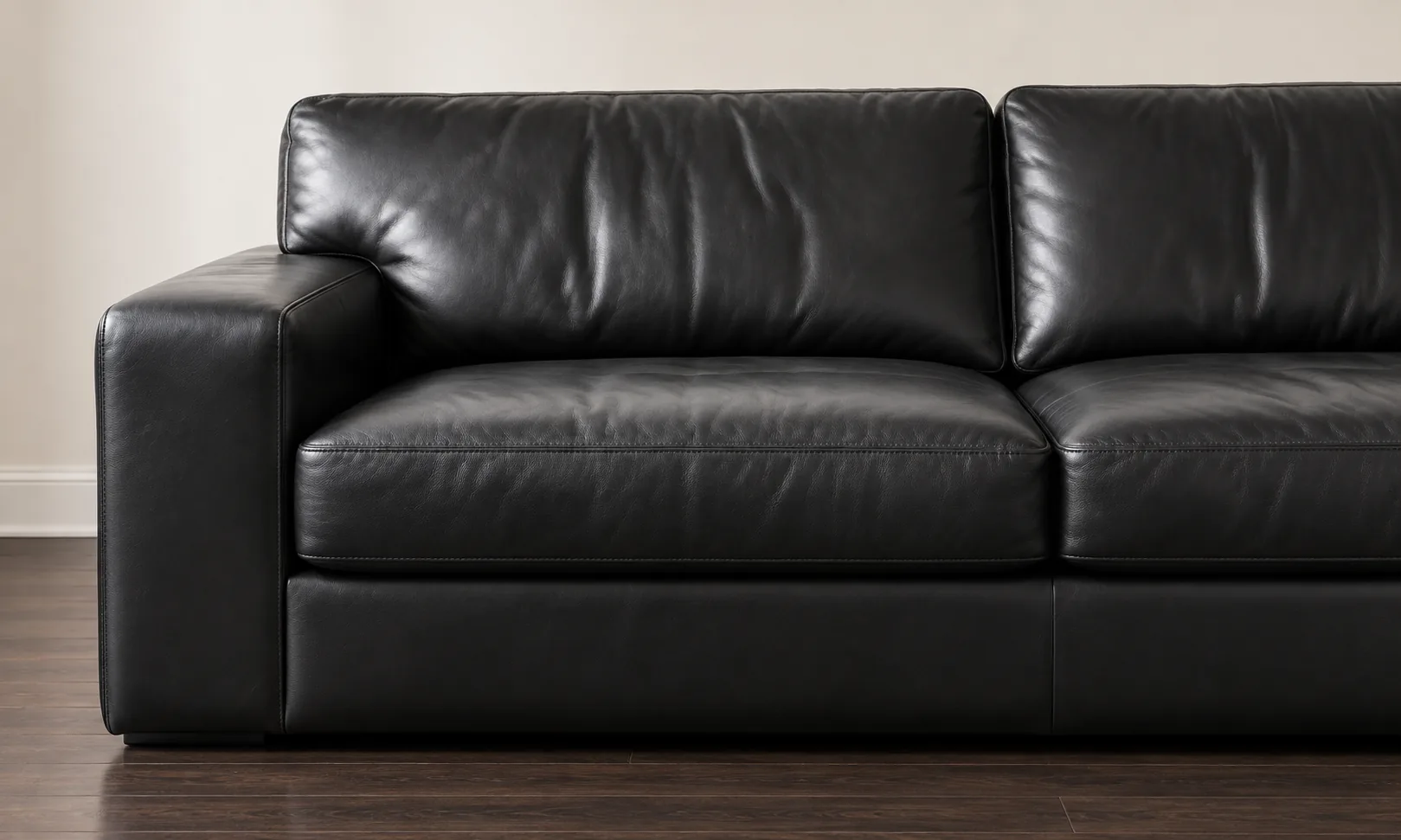 Leather repair contact photo of a black leather sofa arm and seams in daylight