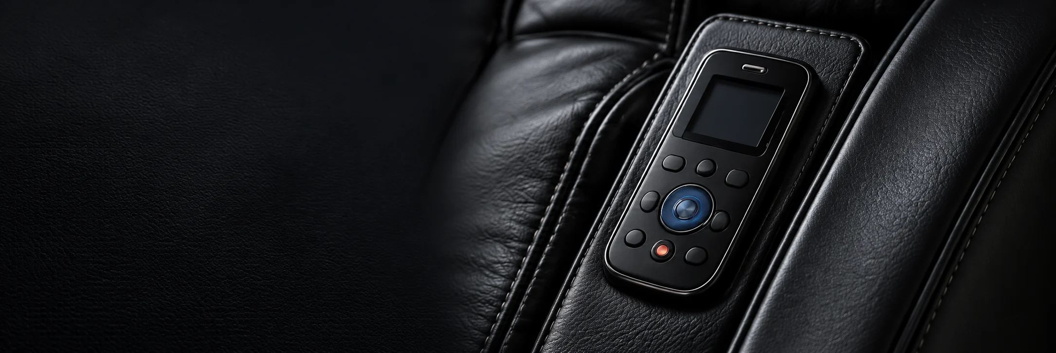 A black leather massage chair armrest with the handheld controller resting in its pocket