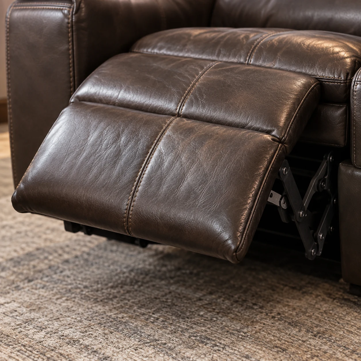 Open power footrest on a brown leather sectional