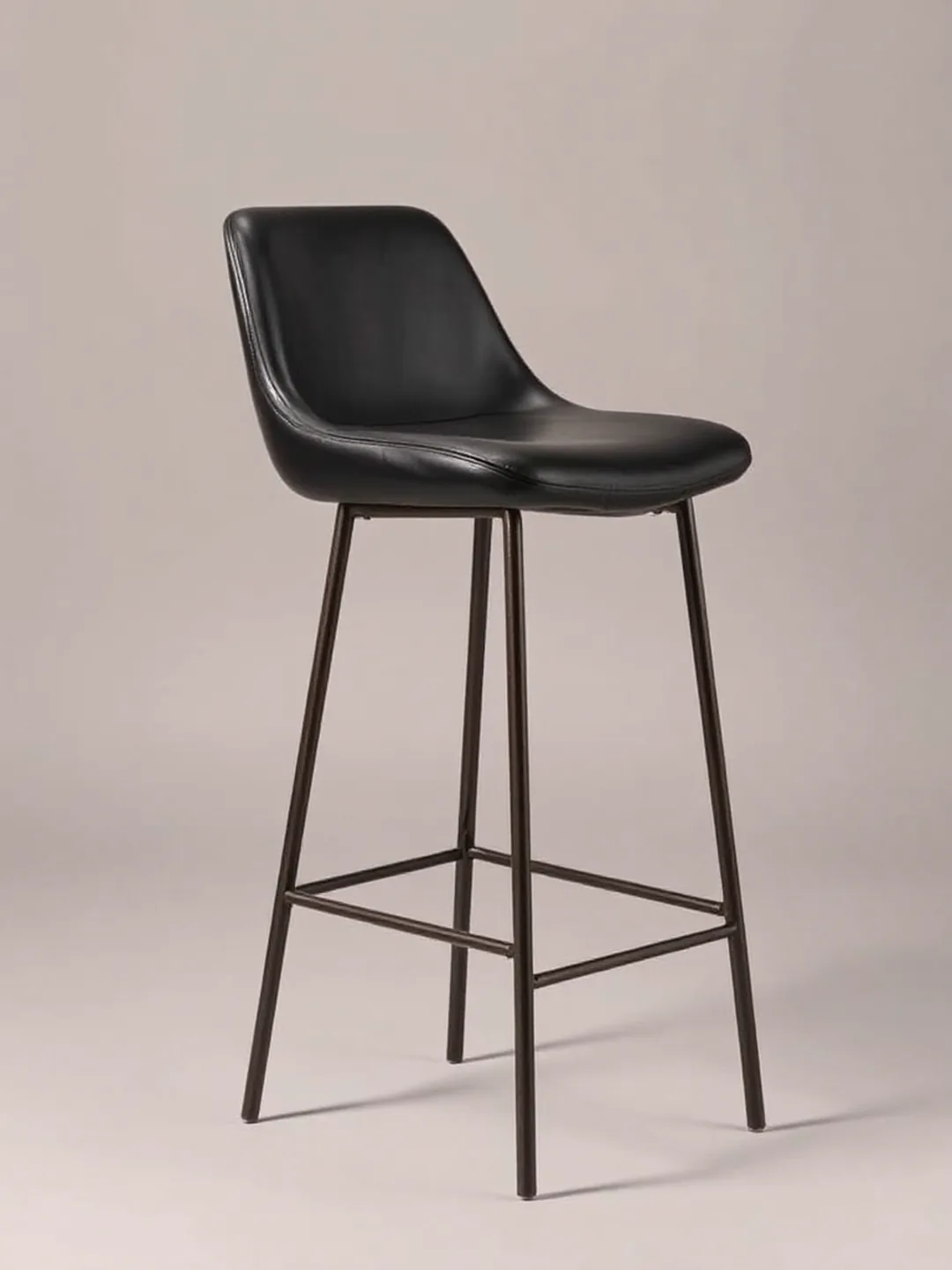 A bar-height upholstered stool with a black leather seat and a metal foot ring, side view