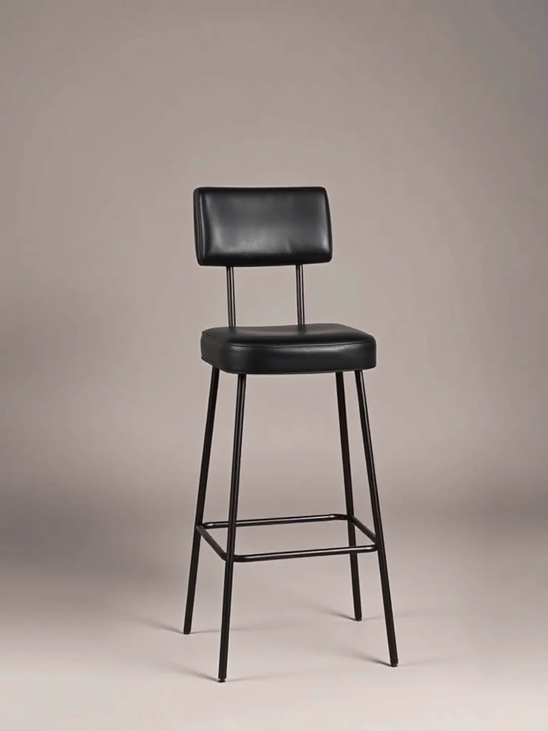 A tall poseur-height upholstered stool on a slim column and round base, side view