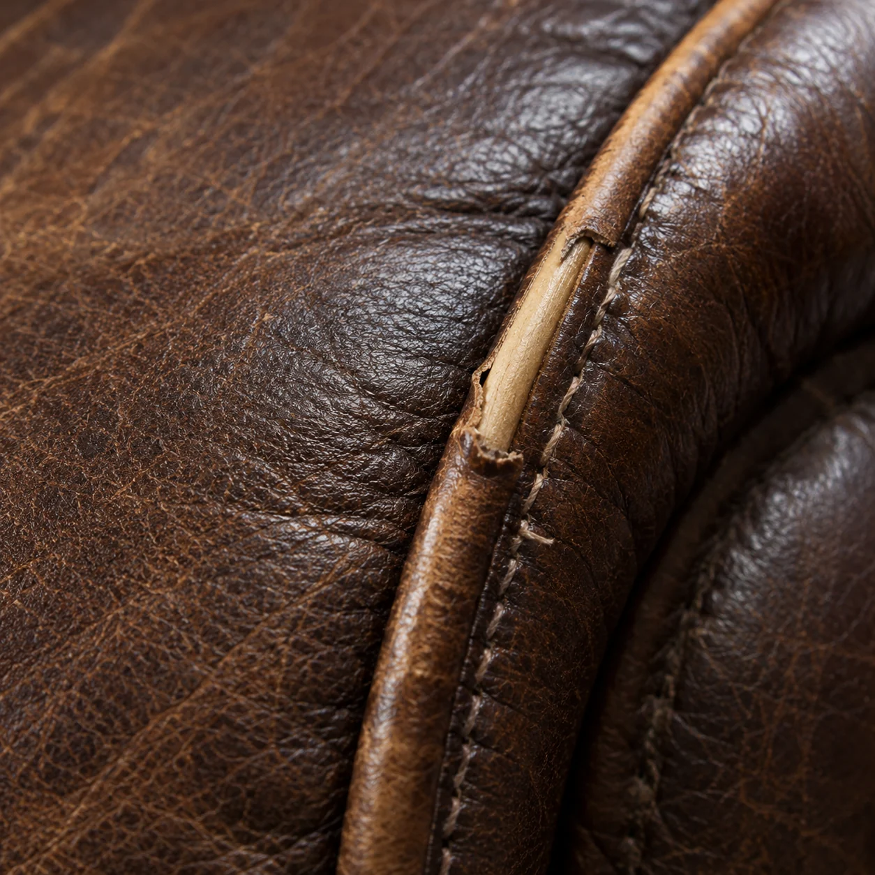 Split welt seam with the piping cord exposed on a leather arm