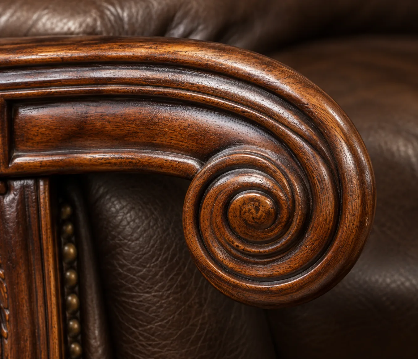 Carved wood scroll on a leather chair arm