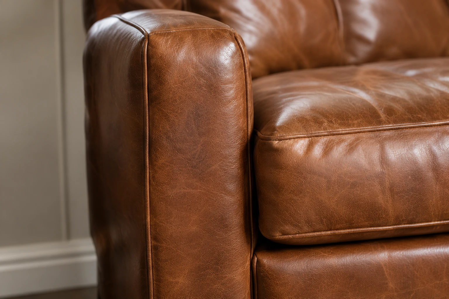 Tan leather club chair with an unmarked arm and seat after repair