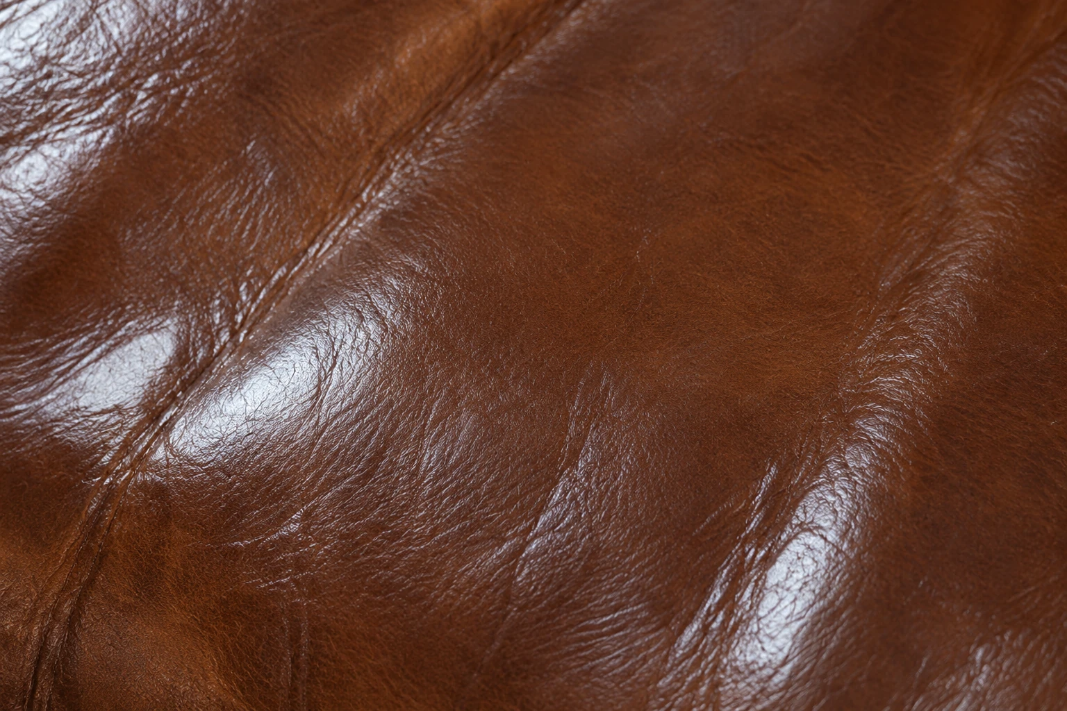 Cognac leather cushion with an even satin sheen across the surface