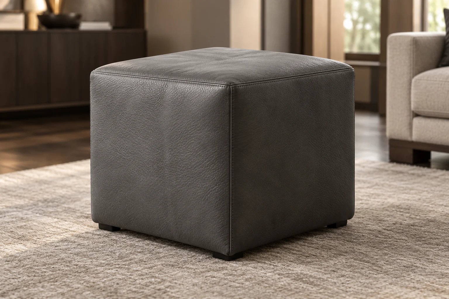 A small charcoal leather cube ottoman