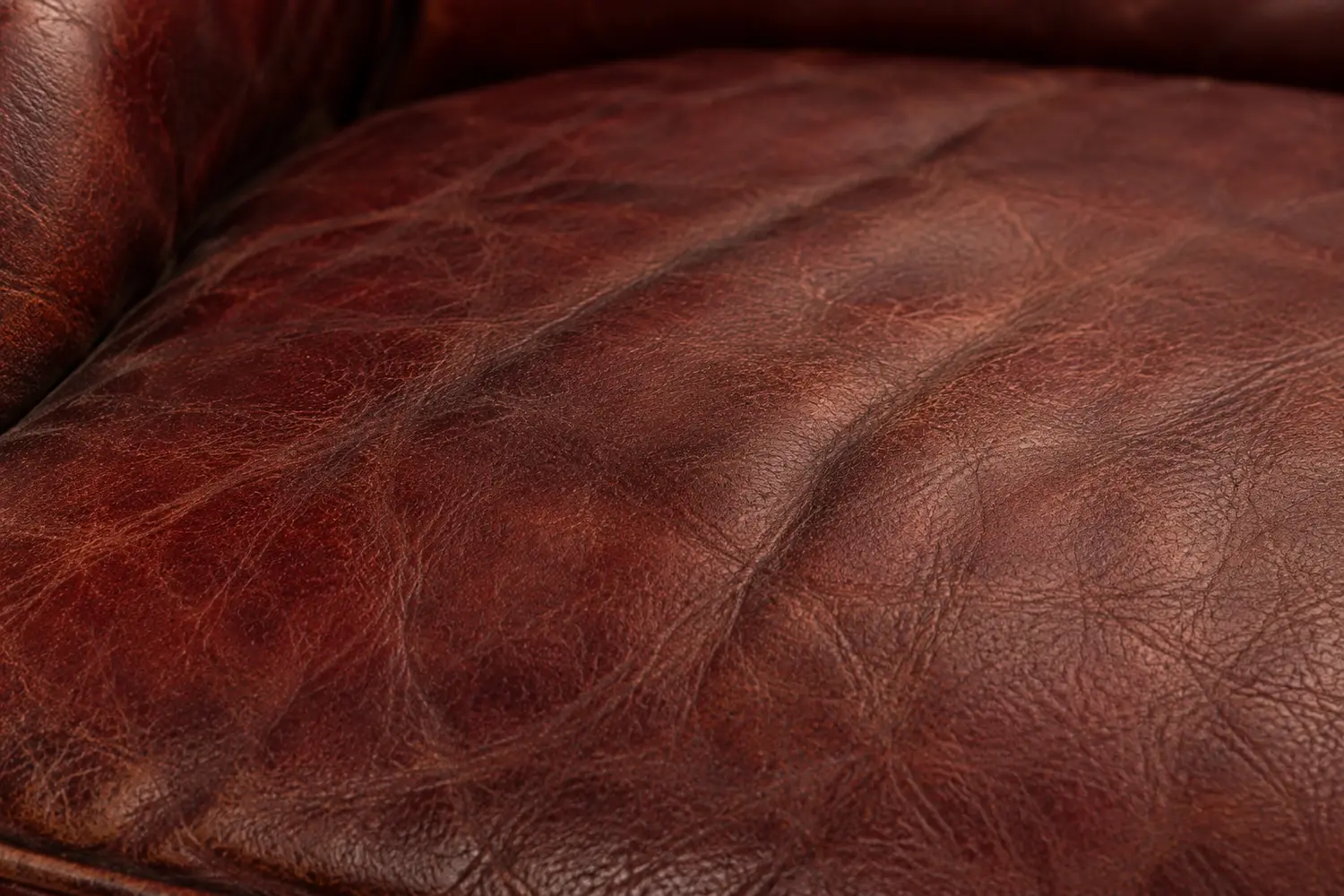 Macro of a club chair surface where the topcoat has worn dull and thin