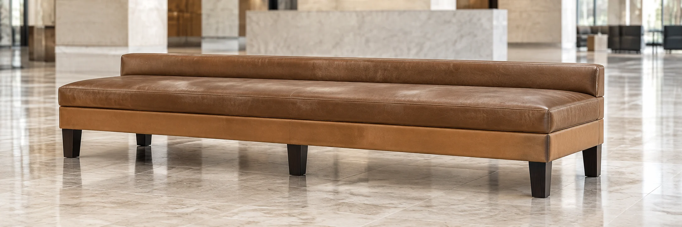 Long tan leather bench in a marble lobby