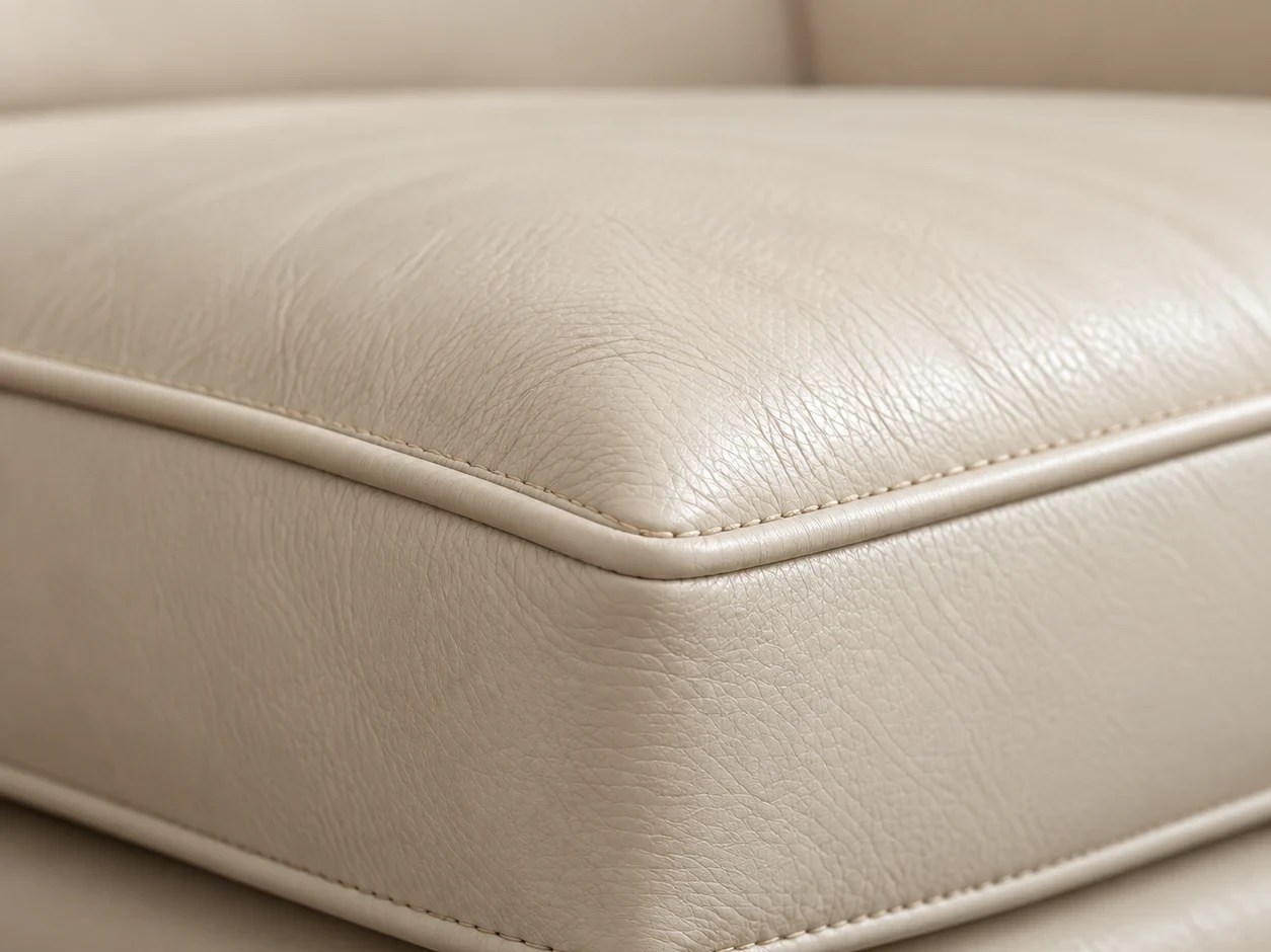 Boxed side band of a cream leather couch cushion