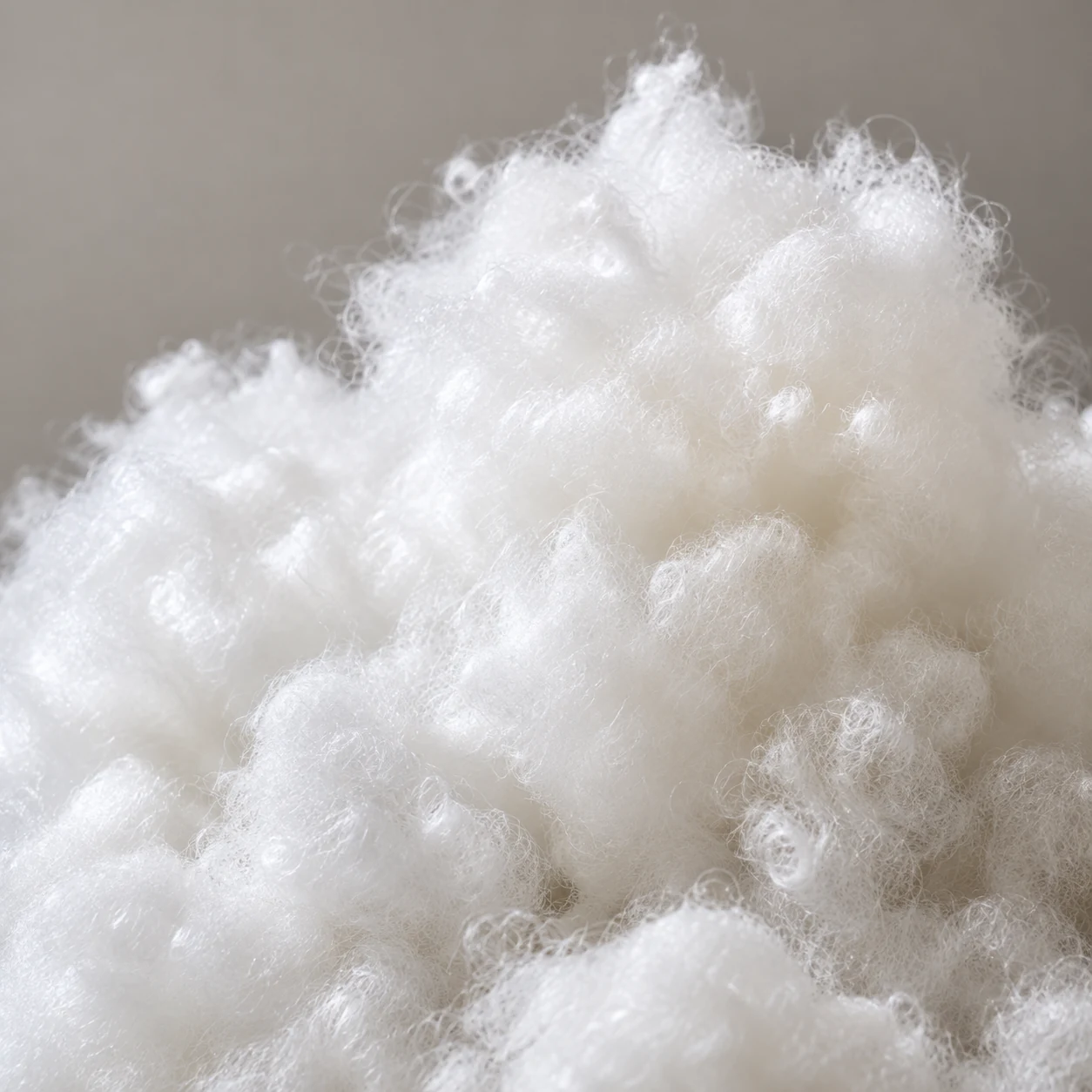 Loose white fiber fill used to refill a couch cushion