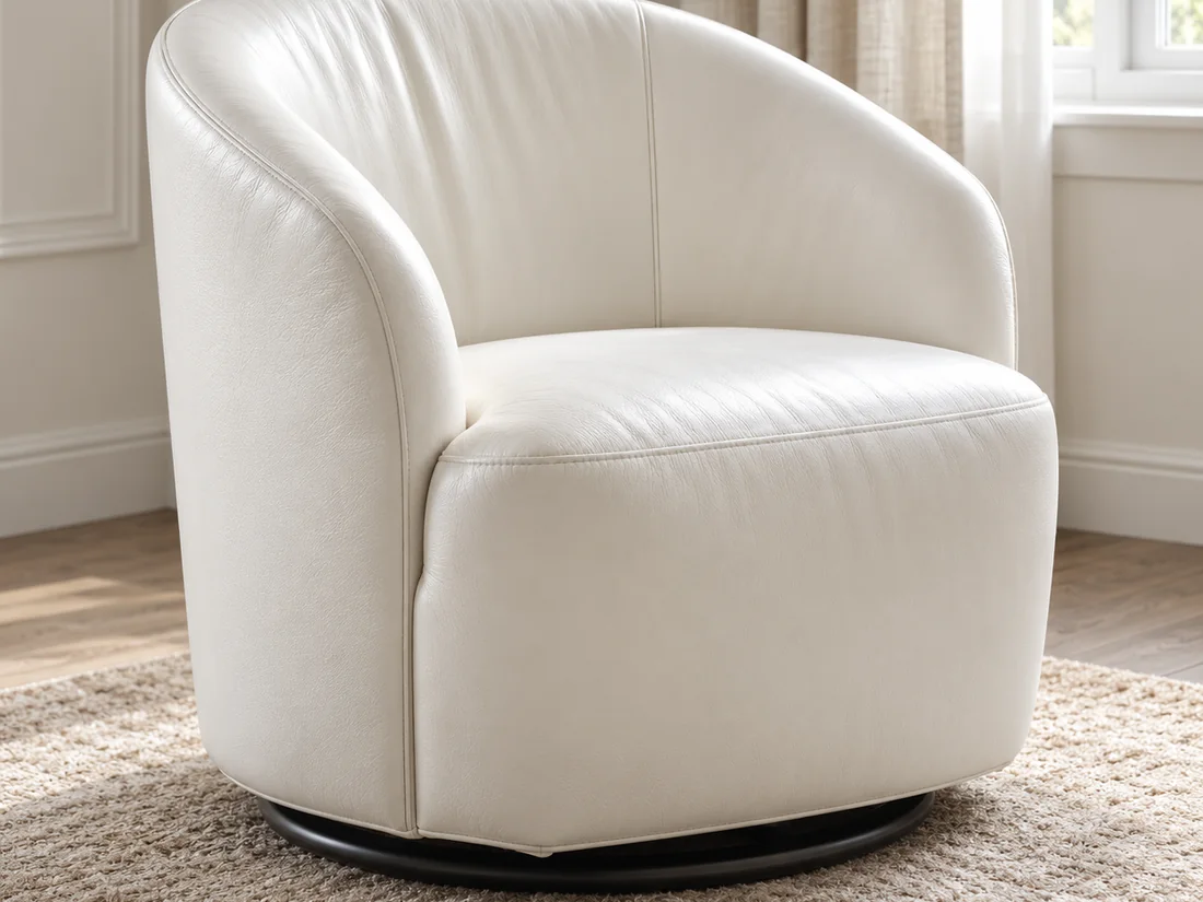 A white leather swivel barrel chair on a wool rug