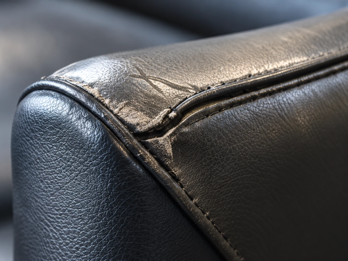 Creased black leather arm front corner on a waiting room chair