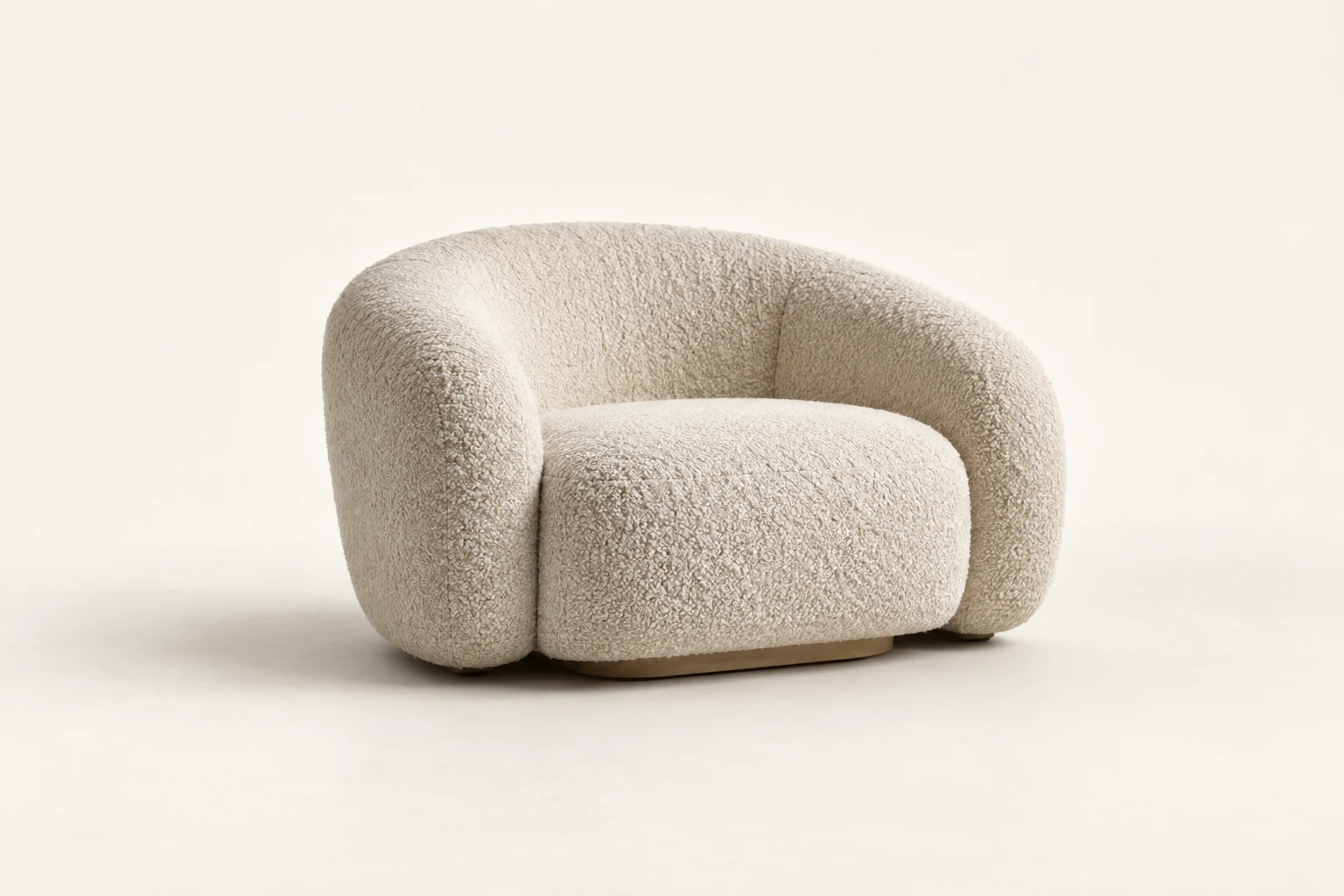 Rounded lounge chair upholstered in cream boucle