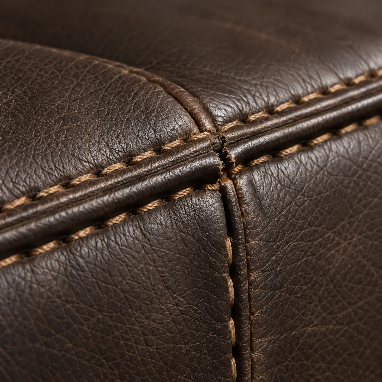 Dark brown bench leather seam rebuilt where two panels meet