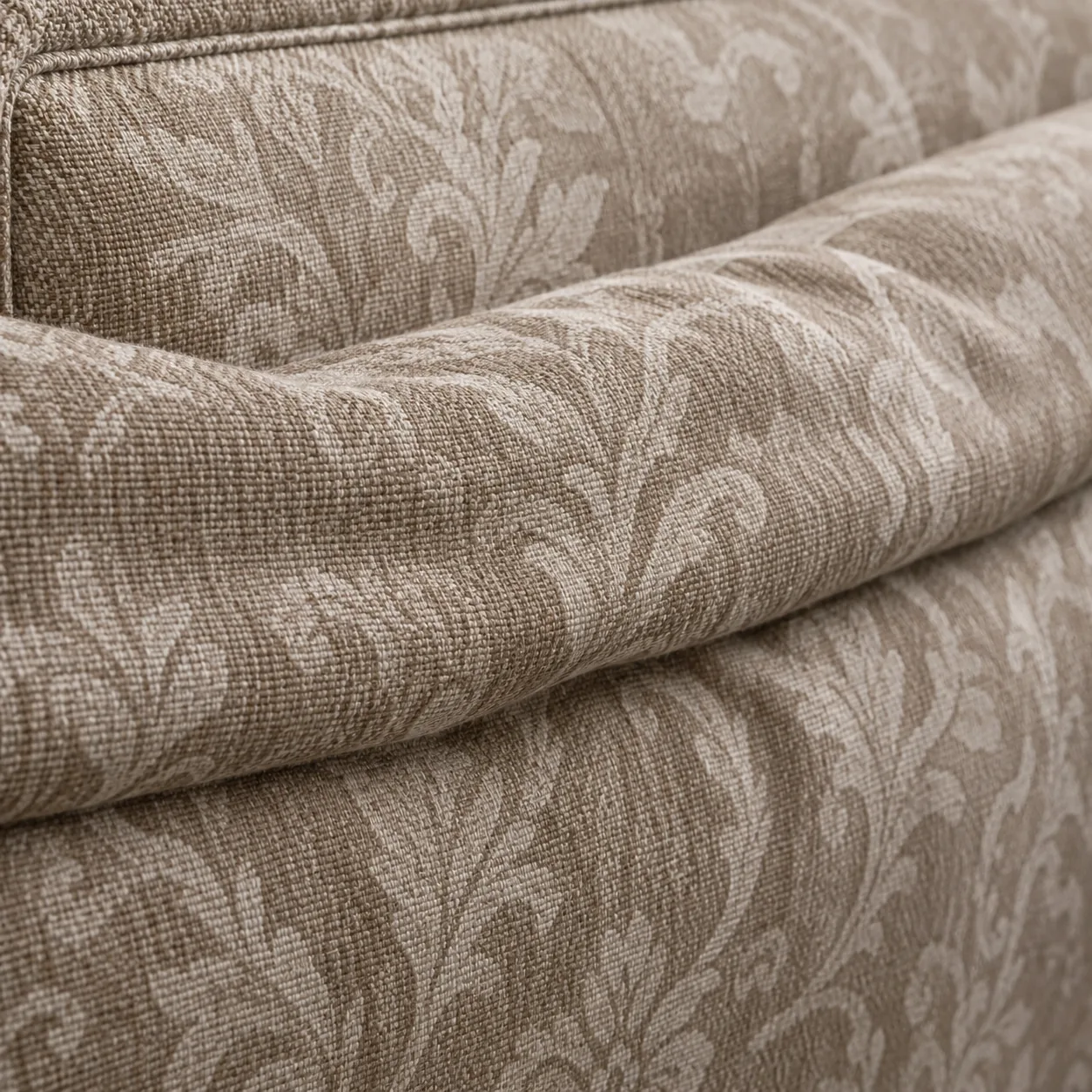 Dated damask jacquard fabric on the rolled edge of a headboard