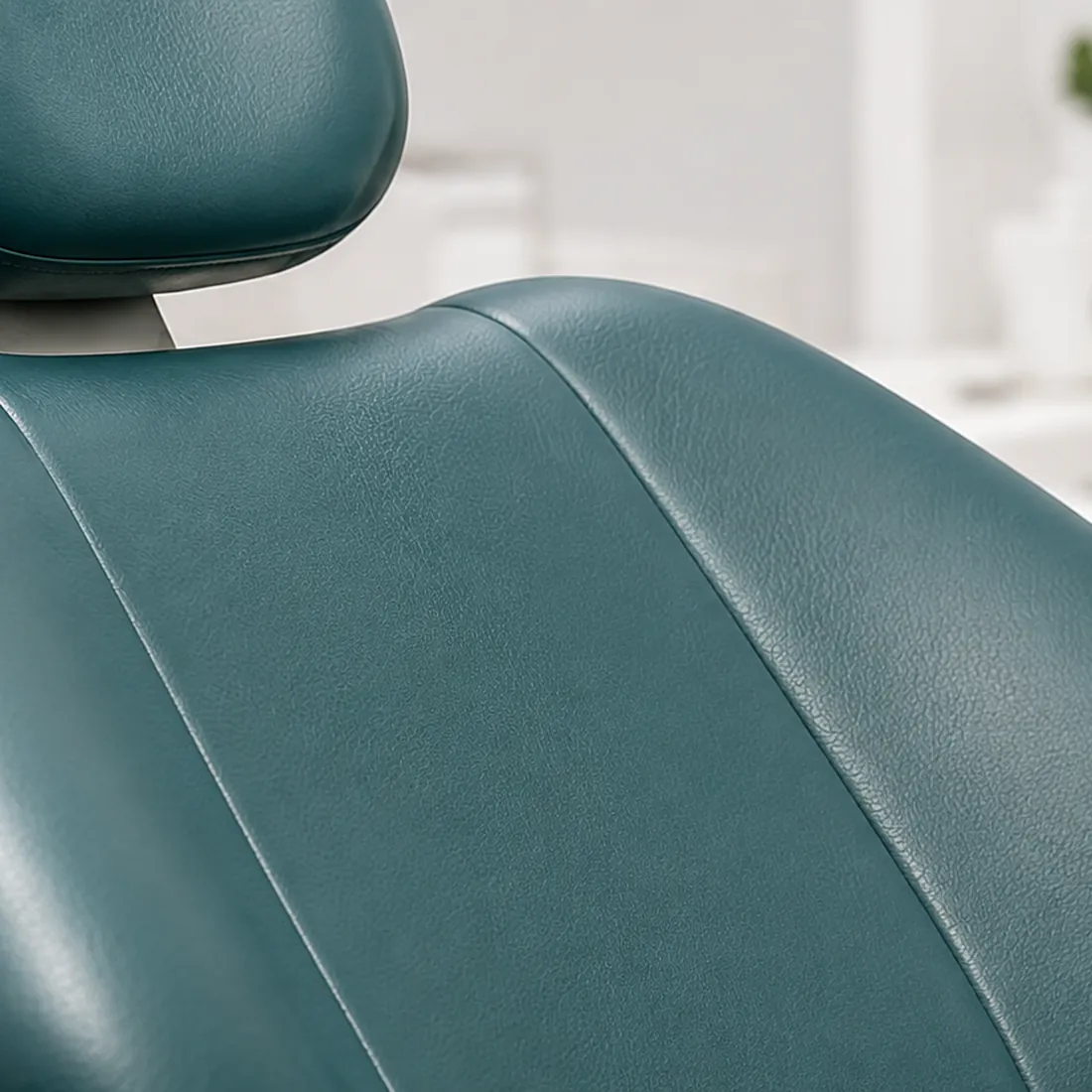 Teal vinyl headrest and upper backrest of a dental chair