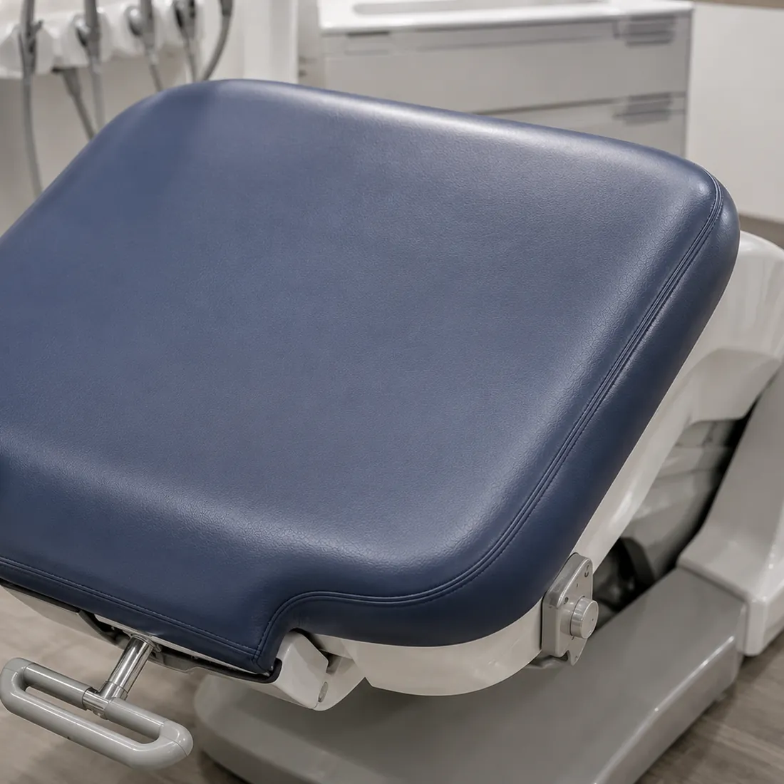 Navy vinyl seat cushion on a dental chair base