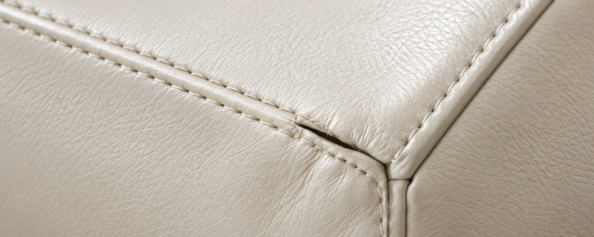 A stitched seam running across a cream leather corner