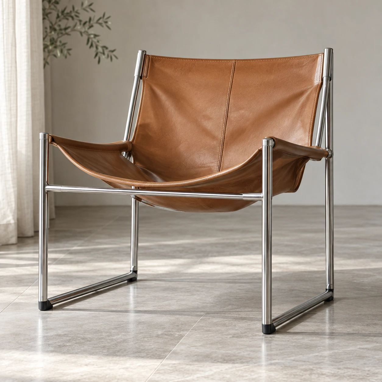 A tan leather sling chair suspended in a chrome frame