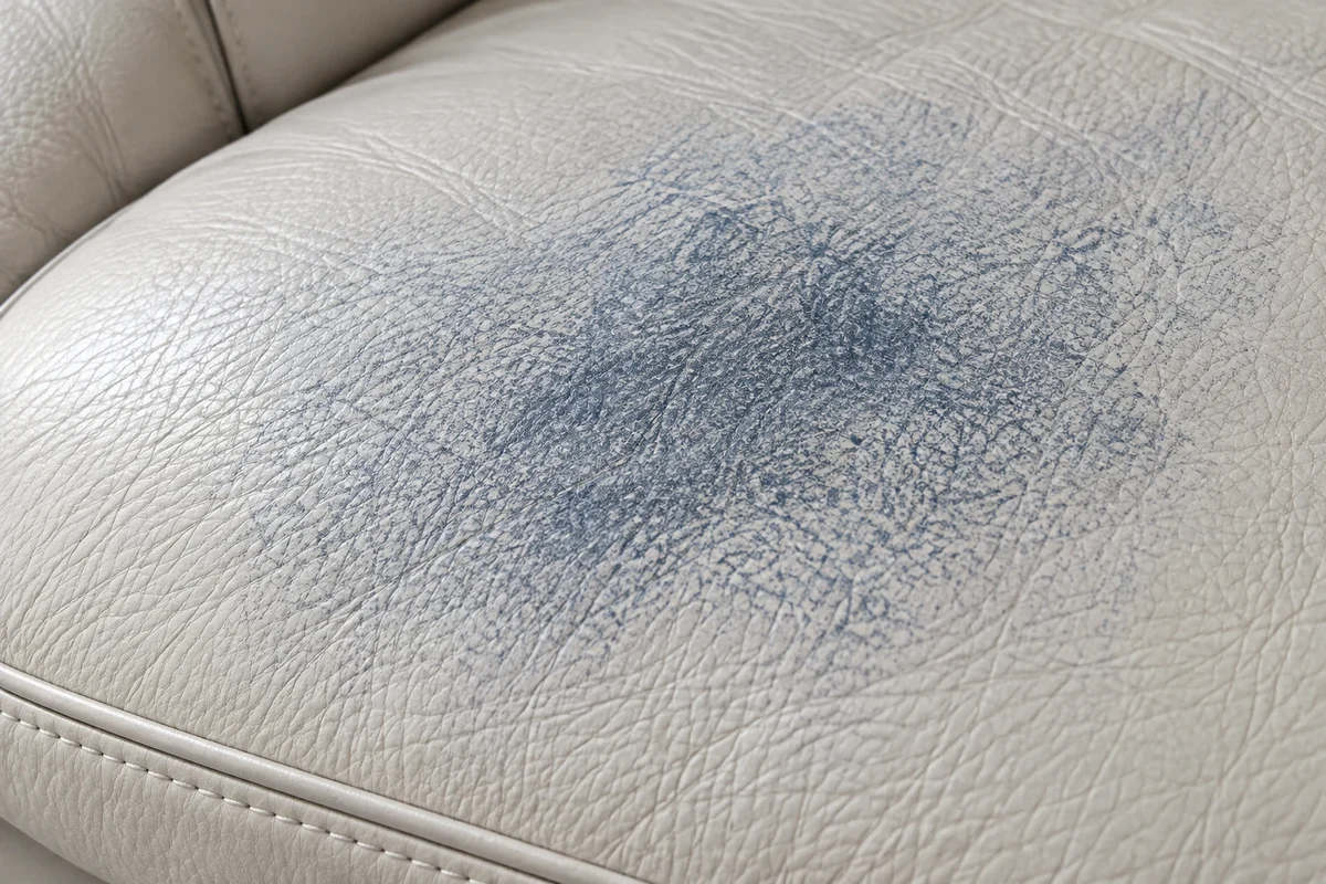 Close view of blue transferred dye held in the finish of pale leather