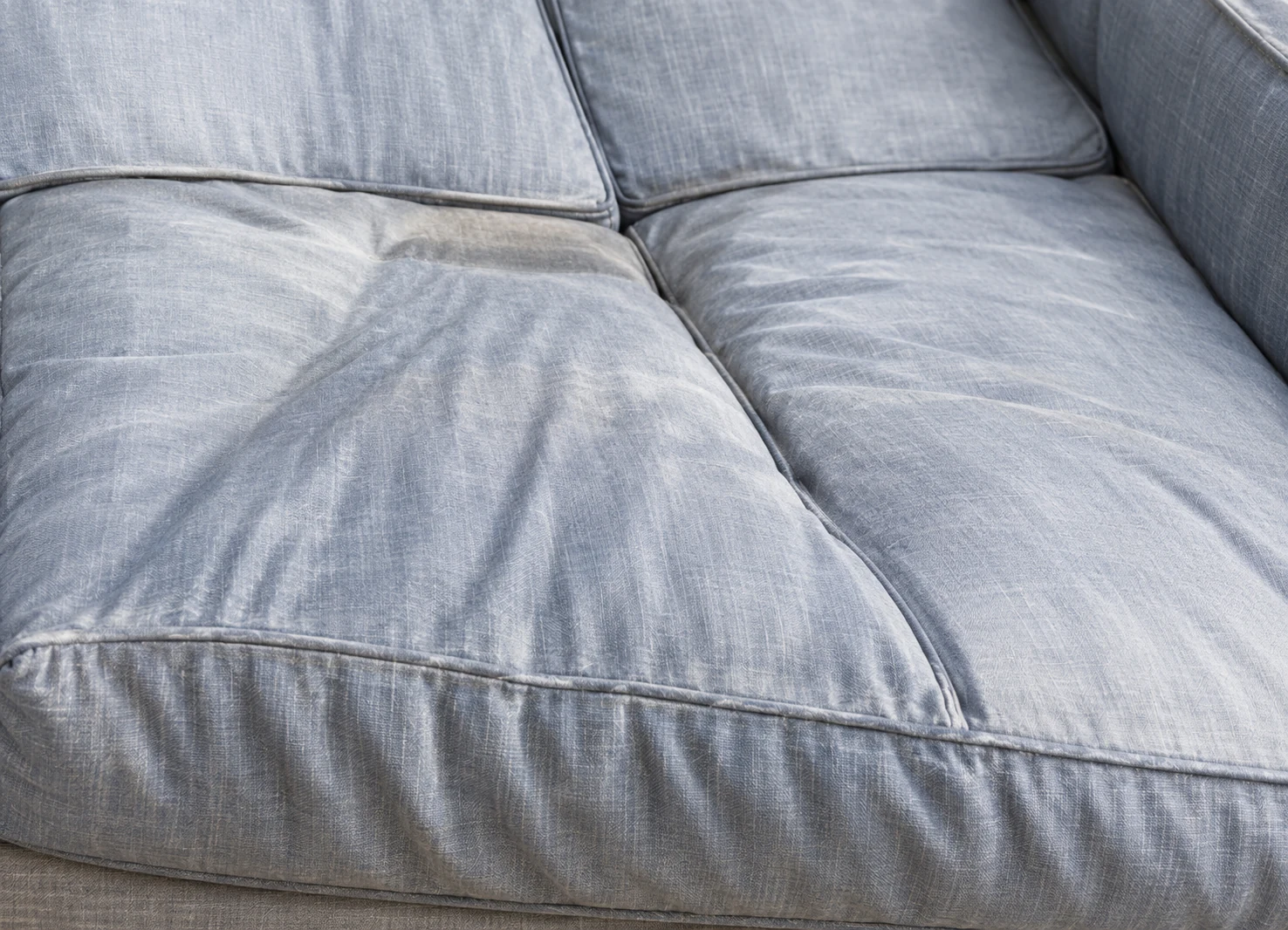 Faded pale grey outdoor cushions sagging in the middle of the seat