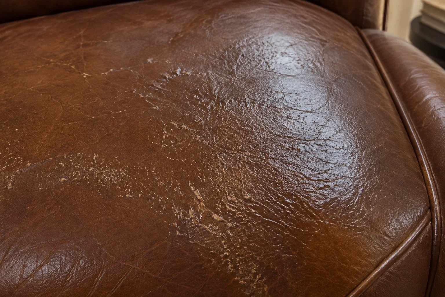 Shiny worn patch on a leather seat where friction has polished the finish