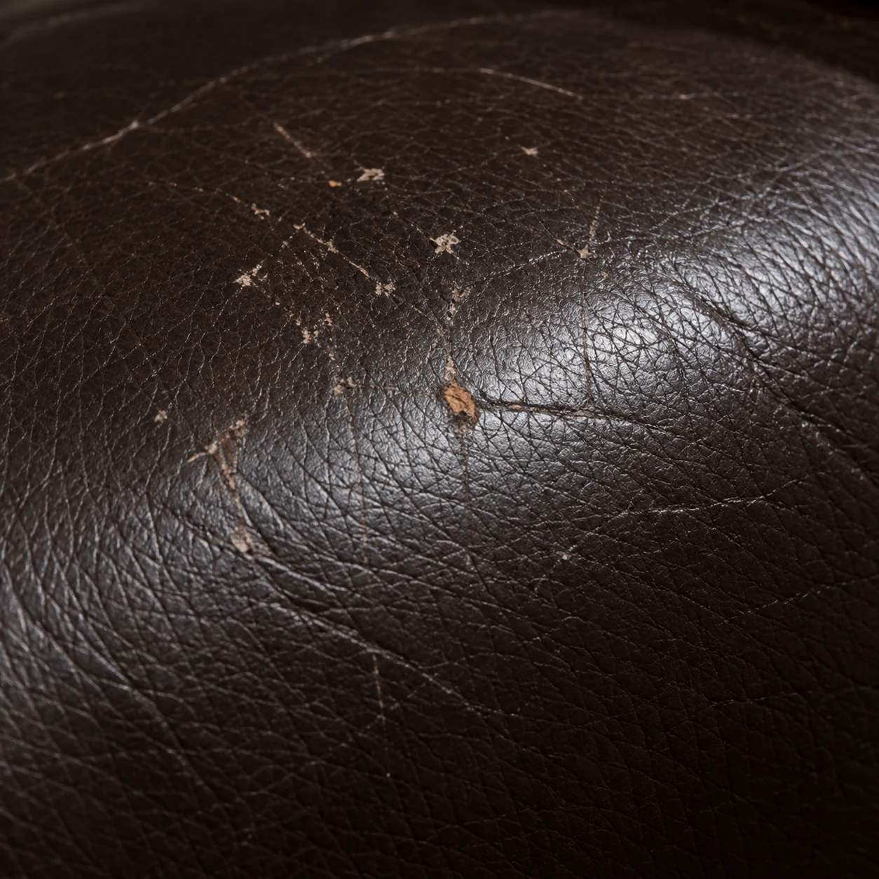 Fine crazing spreading across brown home theater seat leather
