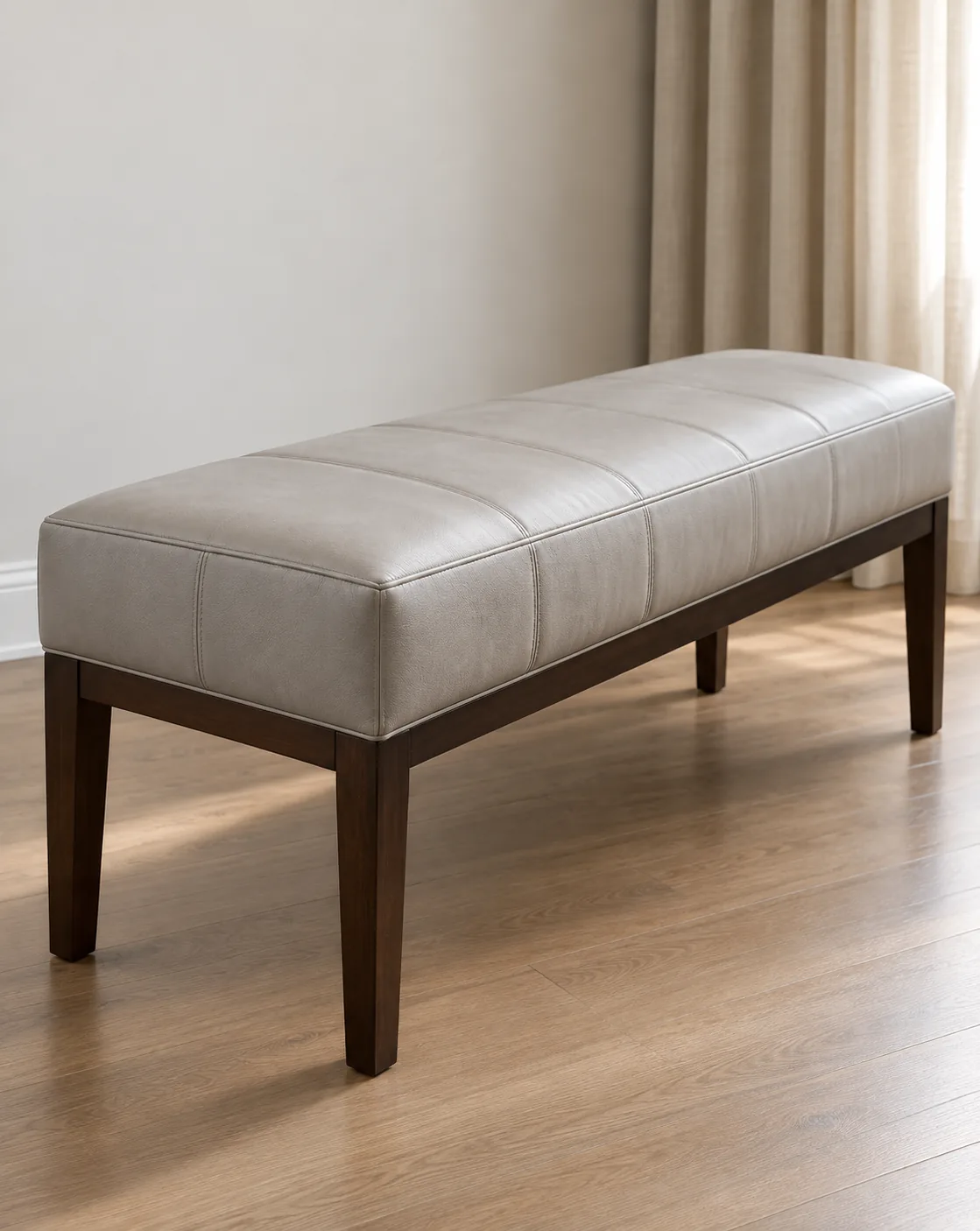 Greige leather bench set against a curtained wall in a living room