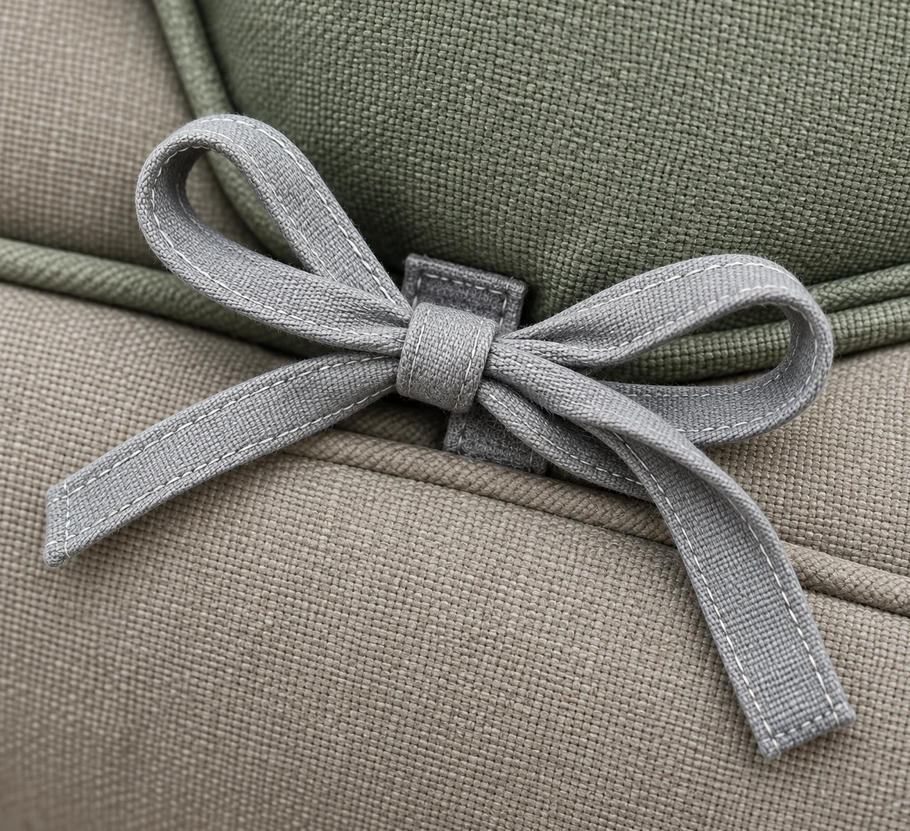 Grey fabric ties finished in a bow on an outdoor cushion