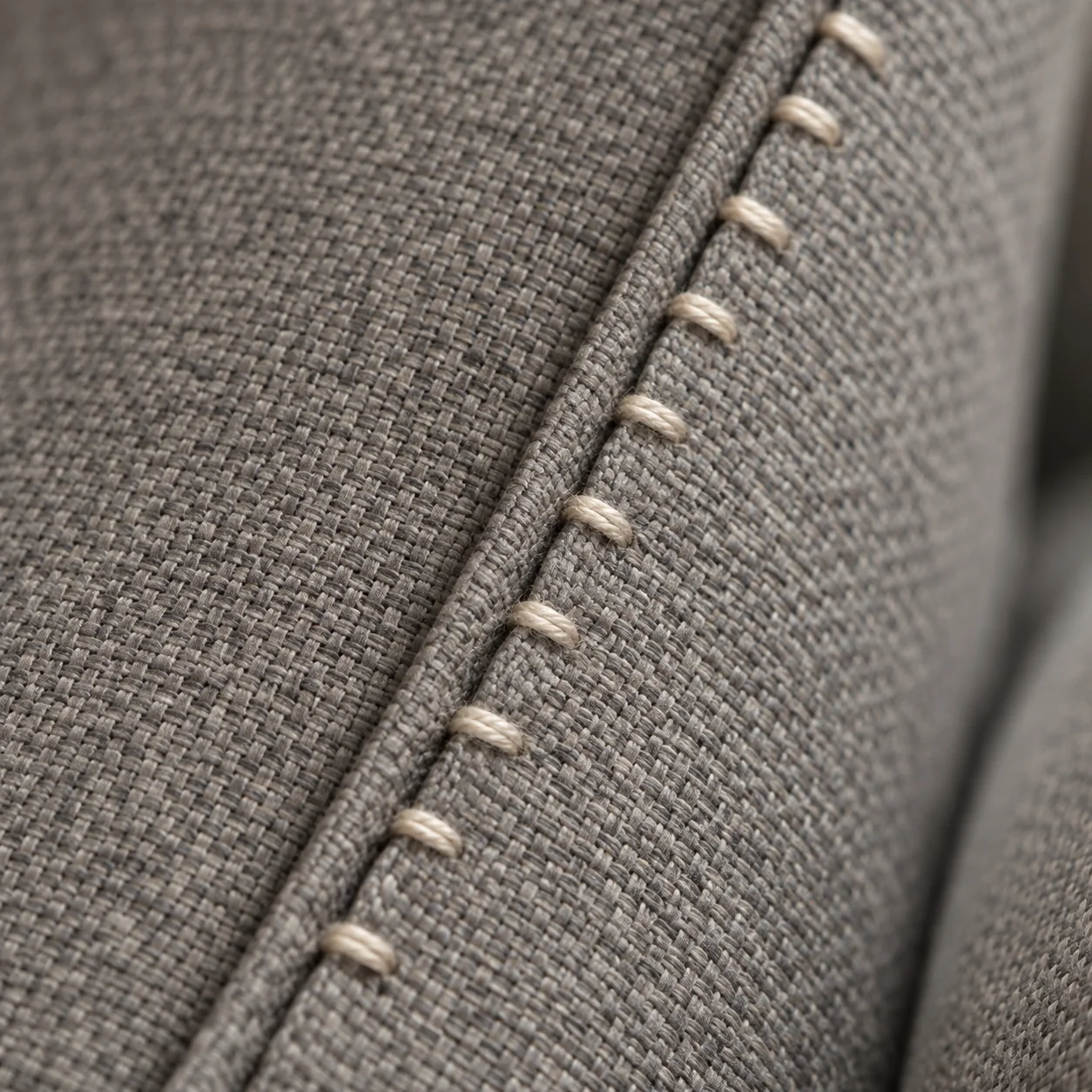 Even hand stitches on a fabric seam