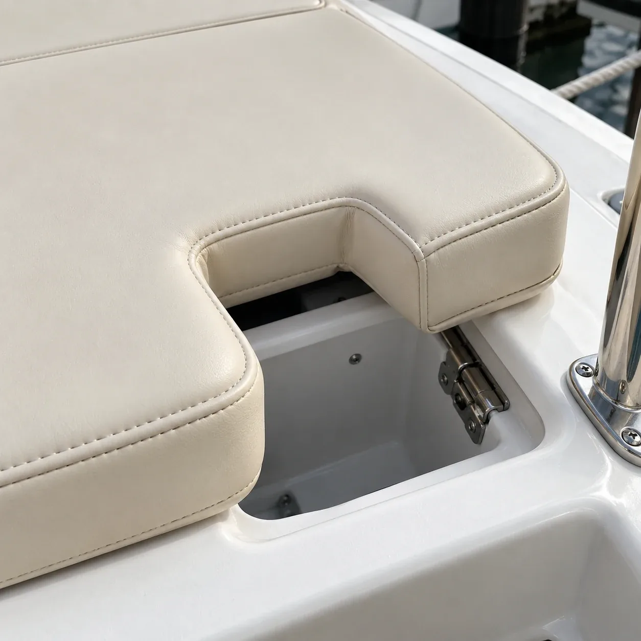 A boat cushion notched around an open locker and its hinge