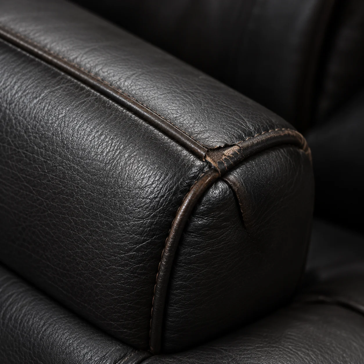 Worn seam and corner on the headrest bolster of a home theater seat
