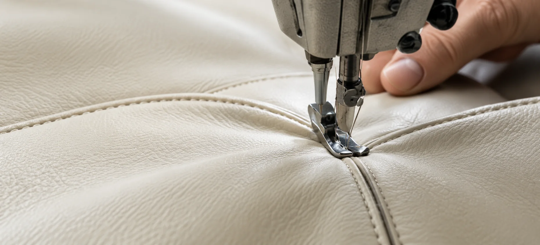 Stitching a cream leather cushion panel on a workshop sewing machine