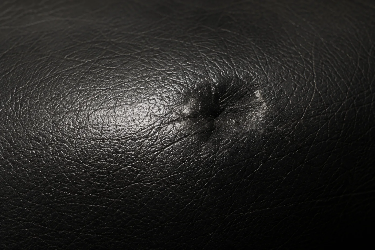 Scuffing on the surface of a black leather Herman Miller cushion