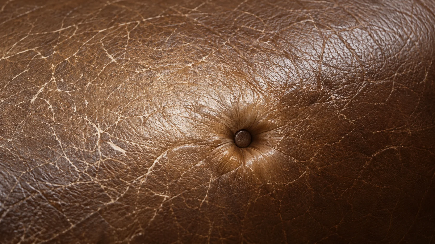 Patch of faded color on brown leather where the pigment has worn away