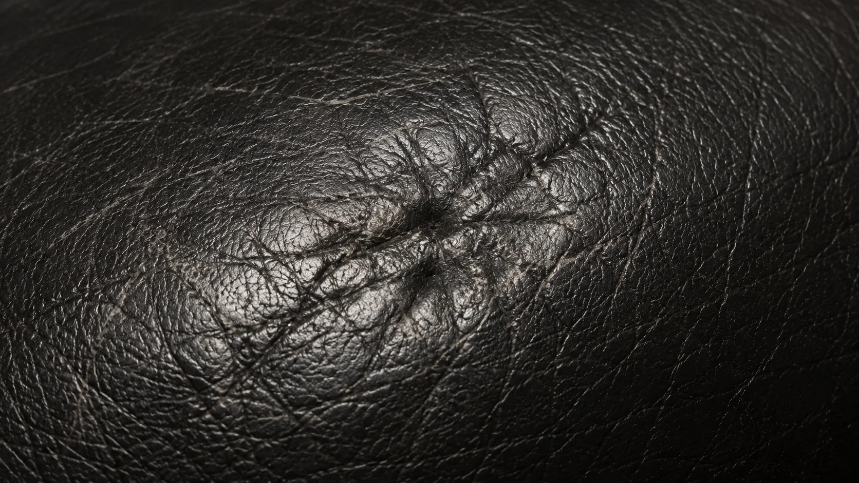 Scuffed black leather with the surface finish rubbed dull