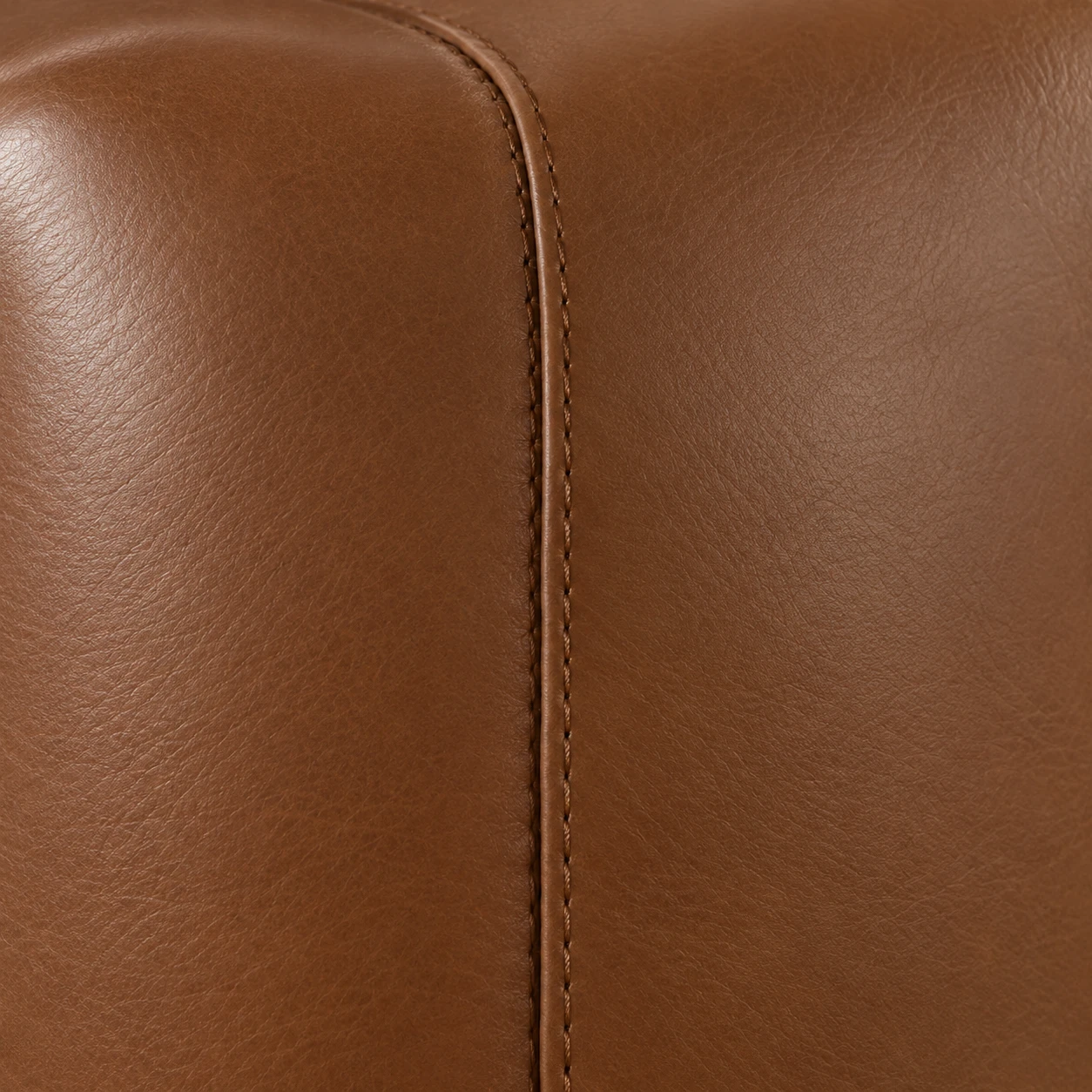 A single straight stitched seam running down the tan leather back panel of a chair