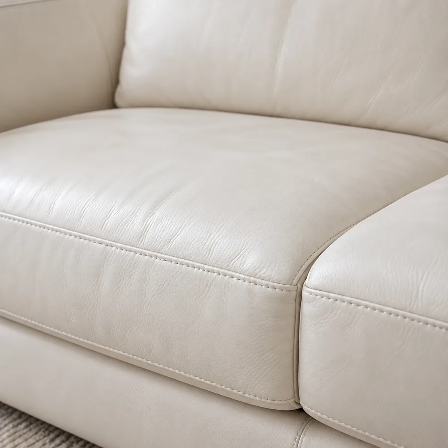 Top of a cream leather back cushion where a head rests against it